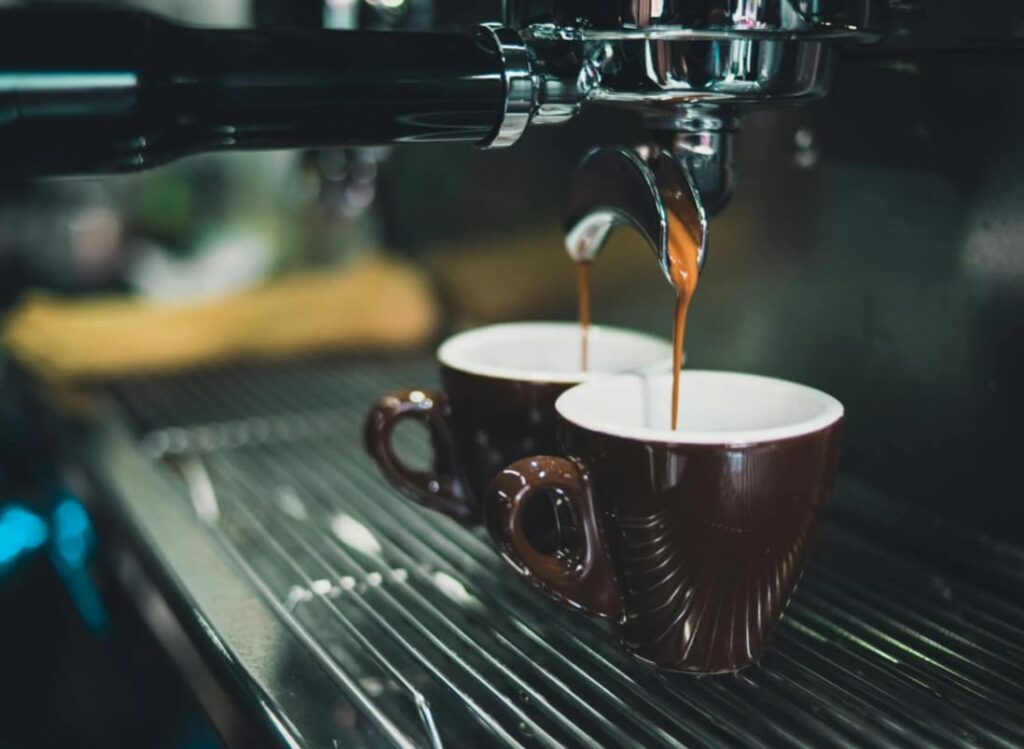 Espresso streaming into brown cups on a coffee machine