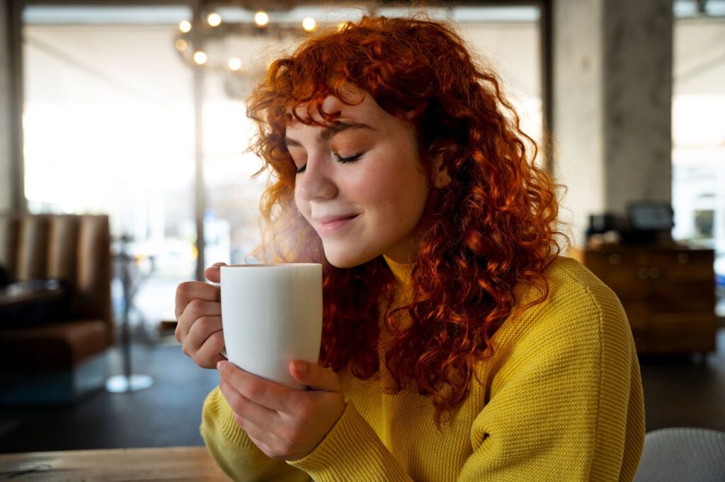 Woman drinking hot coffee at cafe