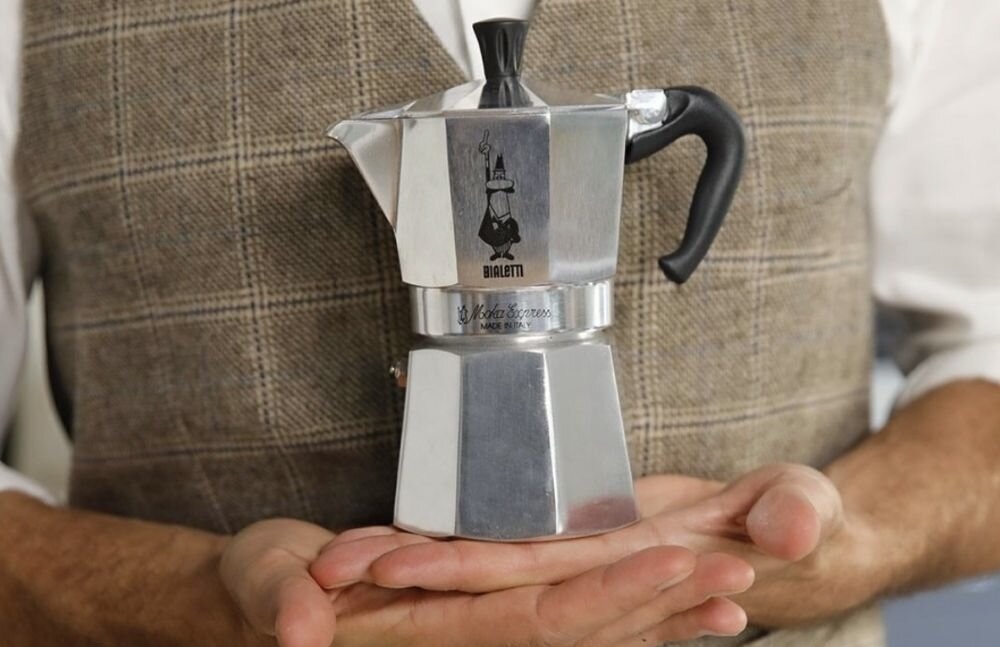 Hands holding coffee maker for making espresso