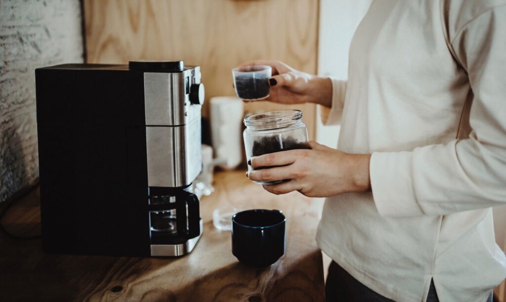 Man making coffee using a coffee machine at home